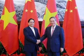 Le Premier ministre vietnamien Pham Minh Chinh (à gauche) et son homologue chinois Li Qiang se serrent la main, à Dalian, en Chine, le 24 juin. Photo: VNA