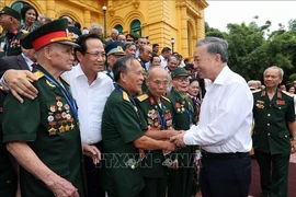 Le président Tô Lâm avec la délégation des personnes ayant rendu des services méritoires à la révolution, à Hanoi, le 22 juillet. Photo: VNA