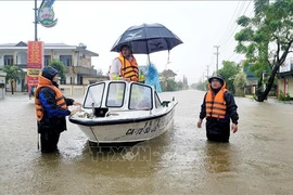 Un canot de la police de la province de Quang Binh en opération de sauvetage et de secours sur une route inondée du district de Lê Thuy. Photo: VNA