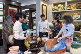 Les membres du Conseil mondial de l'artisanat discutent avec des artistes céramistes talentueux du village de poterie de Bat Tràng. Photo : CTV