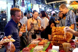 Туристы на фуд-корте ночного рынка Ханоя. (Фото: thanhnien.vn) 