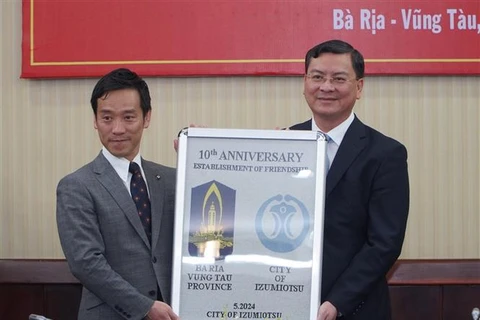 Mayor of Izumiotsu city Minamide Kenichi (left) presents a souvenir marking the 10th anniversary of the two localities' relations to Vice Chairman of the Ba Ria - Vung Tau People’s Committee Nguyen Cong Vinh at the meeting on May 21. (Photo: VNA)