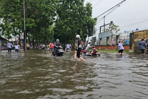 Workers wade through floodwater at the Giao Long Industrial Park in Chau Thanh district, Ben Tre province, due to heavy rains during May 20 night and early May 21. (Photo: VNA)