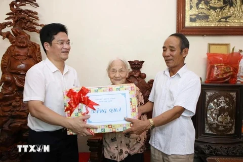 Standing Vice Chairman of the Nam Dinh provincial People's Committee Tran Anh Dung (first, left) presents a gift to Heroic Vietnamese Mother Tran Thi Chuc (centre), born in 1925, in My Thang commune of My Loc district. (Photo: VNA)