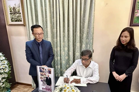 G. Weerasinghe, General Secretary of the Communist Party of Sri Lanka, writes the book of condolences at the respect-paying ceremony held by the Vietnamese Embassy in Sri Lanka on July 25. (Photo: VNA)