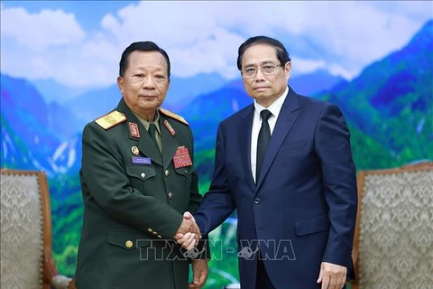 PM Pham Minh Chinh (right) receives General Chansamone Chanyalath, Deputy PM and Minister of National Defence of Laos, in Hanoi on July 25. (Photo: VNA)