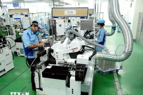 Workers produce electronic components at the factory of the Japanese-invested INOAC Co. Ltd in the Quang Minh Industrial Park of Hanoi. (Photo: VNA)