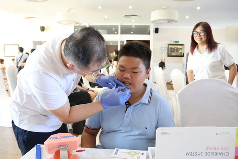 A doctor gives a dental check-up to a child at the September 7 event in the Czech Republic. (Photo: VNA)