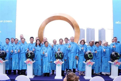 Leaders of HCM City and nearly 40 foreign localities pose for a photo in front of the international friendship symbol on September 24. (Photo: VNA)