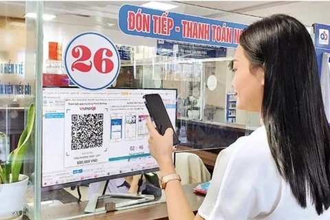 A woman pays for medical examination via QR code at a hospital in Hanoi. (Photo: nhandan.vn)