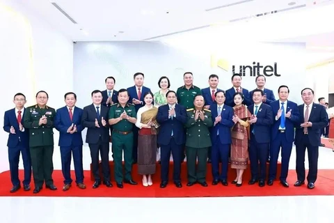 Prime Minister Pham Minh Chinh (front, centre) and executives and staff members of Star Telecom (Unitel) pose for a group photo on October 8. (Photo: VNA)