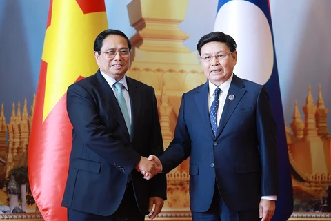 Vietnamese Prime Minister Pham Minh Chinh (left) meets with Chairman of the Lao National Assembly Saysomphone Phomvihane in Vientiane on October 8. (Photo: VNA)