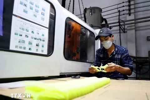 Un ouvrier fabrique des moules en plastique pour produire des chaussures en cuir dans une usine située à la ville de Thuan An, province de Binh Duong. Photo: VNA