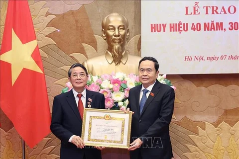 El presidente parlamentario Tran Thanh Man (derecha) entrega la insignia por 40 años de membresía del PCV a Nguyen Duc Hai, miembro del Comité Central del Partido y miembro del Comité de asuntos partidistas de la AN y vicepresidente del Parlamento. (Fuente:VNA)