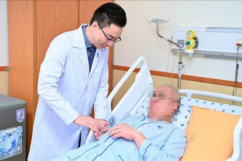 Médico del Hospital de Medicina y Farmacia de la Universidad de Ciudad Ho Chi Minh examina al paciente extranjero. (Fuente:VNA)