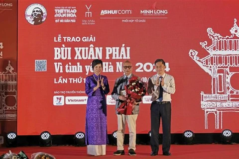 La directora general de la Agencia Vietnamita de Noticias, Vu Viet Trang, entrega el Gran Premio al arquitecto Hoang Dao Kinh. (Fuente: VNA)