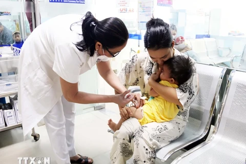 Personal médico inyecta vacuna a un niño. (Foto: Vietnam+)