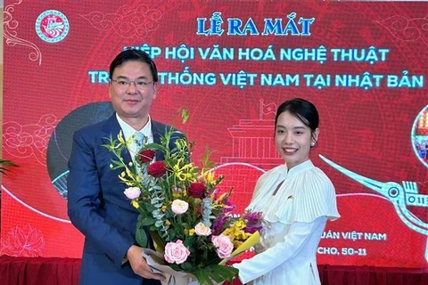 El embajador de Vietnam en Japón, Pham Quang Hieu, entrega un ramo de flores a la presidenta de la asociación de cultura y arte tradicional vietnamita en Japón, Do Khanh Han. (Foto: VNA)