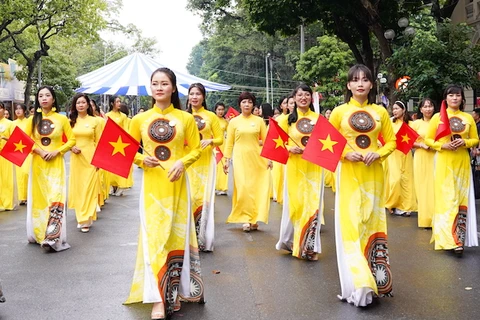 越南女性身穿奥黛跳民间舞蹈活动。图自越共电子报