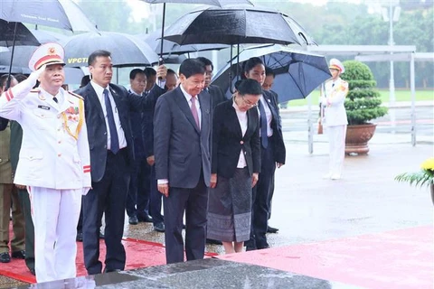 Le secrétaire général du Parti populaire révolutionnaire lao et président du Laos Thongloun Sisoulith et son épouse, accompagnés d'une délégation de haut rang du Parti et de l'État du Laos, rend hommage au Président Hô Chi Minh en son mausolée. Photo: VNA