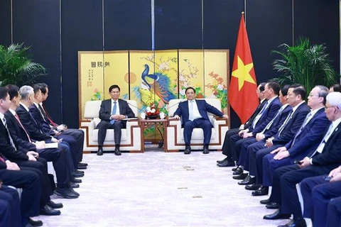 Le PM Pham Minh Chinh (droite) rencontre le président de la région autonome Zhuang du Guangxi (Chine) Lan Tianli. Photo: VNA