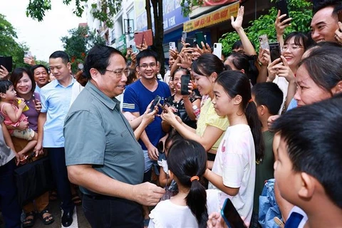 El primer ministro Pham Minh Chinh con los residentes del proyecto de vivienda social Thong Nhat. (Foto: VNA)