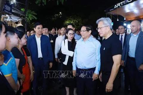 El primer ministro vietnamita, Pham Minh Chinh, y el fundador y presidente del gigante tecnológico NVIDIA, Jensen Huang, se reúnen con pobladores y turistas. (Fuente: VNA)