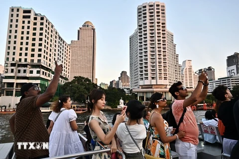 Les touristes font une promenade en bateau sur la rivière Chao Praya à Bangkok, en Thaïlande. Photo : AFP/VNA