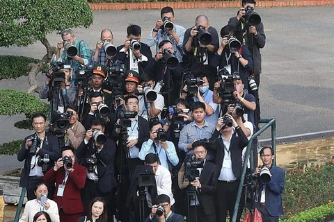 Reporters de la VNA et leurs collègues lors de la cérémonie d'accueil du secrétaire général et président chinois Xi Jinping en décembre 2023 à Hanoï. Photo : VNA