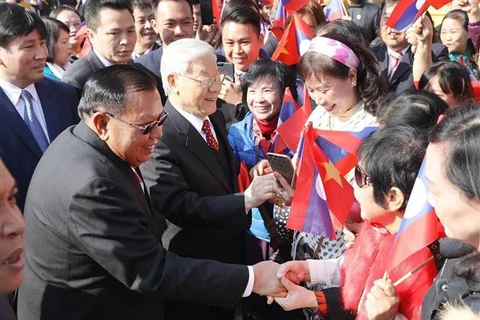 Le secrétaire général Nguyen Phu Trong et le secrétaire général et président du Laos Bounnhang Vorachith et des habitants de Hanoï, le matin du 19 décembre 2017. Photo : VNA