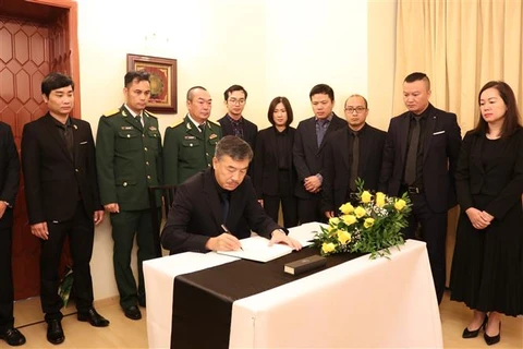 L'ambassadeur du Vietnam en République tchèque Duong Hoai Nam écrit dans le registre de condoléances. Photo : VNA