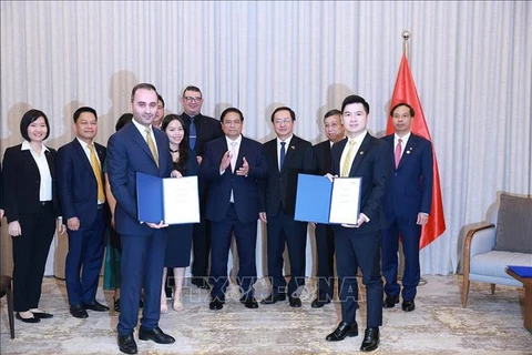 Le Premier ministre Pham Minh Chinh (centre) assiste à la remise du protocole d'accord sur la recherche d'investissement dans le projet de complexe sportif et de centre commercial à Dong Anh entre T&T du Vietnam et JTA International Holding. Photo : VNA