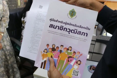 An official gives a senator candidate handbook and an application form to a woman applying for the senate election at Khon Kaen's registration office in Muang district on May 10 (Photo: Bangkokpost.com)