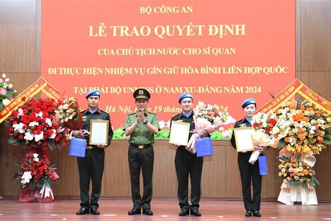 Authorised by the President, Minister of Public Security Sen. Lieut. Gen. Luong Tam Quang presents the decisions to the three officers (Photo: VNA)