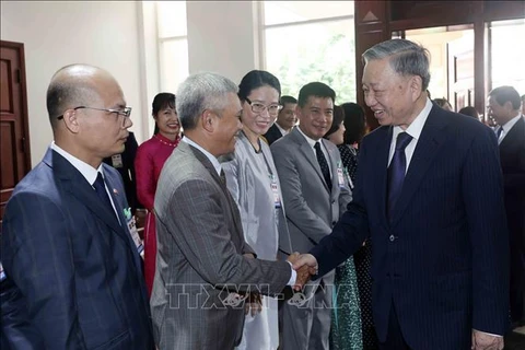 State President To Lam (R) meets Vietnamese Embassy staff and representatives of the Vietnamese community in Laos (Photo: VNA)