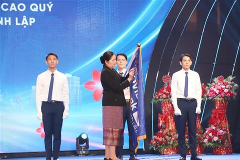 Acting Governor of the Bank of the Lao PDR Vathana Dalaloy, on behalf of the Lao state, presents first-class Labour Order to LaoVietBank (Photo: VNA)