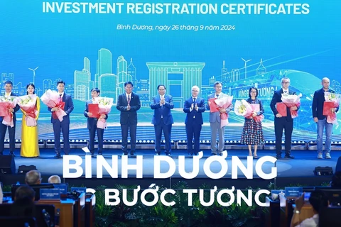 Prime Minister Pham Minh Chinh (C) and investors in Binh Duong province (Photo: VNA)