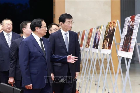 Prime Minister Pham Minh Chinh (1st row, left) introduces Chairman of the Chinese People's Political Consultative Conference (CPPCC) National Committee Wang Huning to photos of some foreign affairs activities of the late Party General Secretary Nguyen Phu Trong. (Photo: VNA)