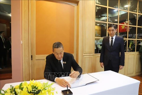 Thai Prime Minister Srettha Thavisin writes in the condolence book at the respect-paying ceremony at Vietnamese Embassies in Thailand on July 25. (Photo: VNA)