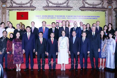 Participants pose for a group photo at the banquet. (Source: VNA)