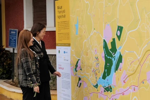 Two women look at the art tourism map of Da Lat. (Photo: baolamdong.vn)