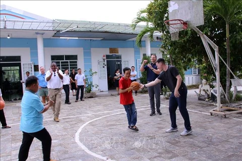 A basketball match with the children cared at the centre takes place as part of the visit. (Photo: VNA)