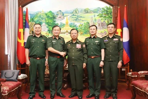 From left: Vietnamese Deputy Minister of National Defence Sen. Lieut. Gen Hoang Xuan Chien (2nd) and Lao Deputy Prime Minister and Minister of National Defence Gen. Chansamone Chanyalath (3rd) in a group photo at their meeting in Vientiane on October 10. (Photo: VNA)