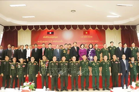 Participants pose for a group photo at the October 24 meeting marking the 75th anniversary of the traditional day of Vietnam’s volunteer soldiers and experts in Laos. (Photo: VNA)