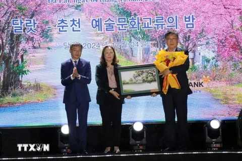 A leader of Da Lat city presents a painting as a gift to a representative of Chuncheon city (right) of the RoK at the exchange on December 4. (Photo: VNA) 