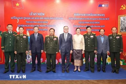 Participating Vietnamese and Lao delegates pose for a group photo at the ceremony. (Source: VNA)