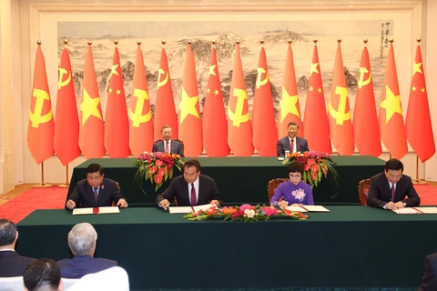 Ceremonia de firma del Acuerdo de Cooperación entre la Agencia Vietnamita de Noticias d y la Agencia de Noticias Xinhua (derecha) y la cooperación en materia de inversiones (izquierda) entre los dos países. (Fuente: VNA)