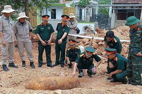 Authorities inspect and devise a plan to safely dispose of the 334 kg bomb. (Photo: VNA)