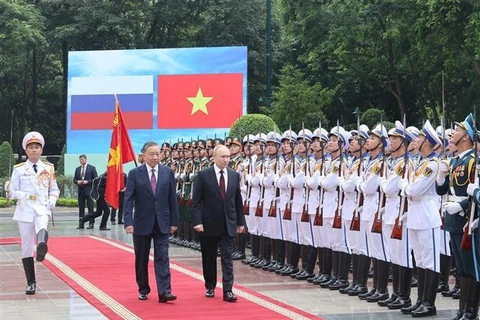 President To Lam (left) and President Vladimir Putin review the Honour Guard of the Vietnam People's Army in Hanoi on June 20. (Photo: VNA)