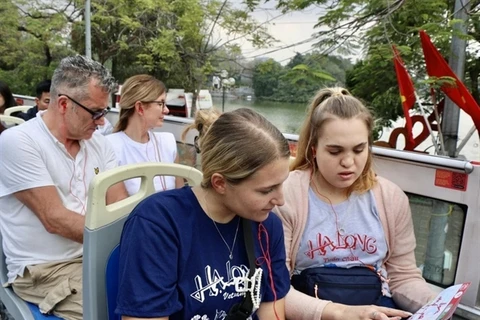 Visitors explore HCM City by double-decker bus. A sustained recovery in tourist arrival numbers will give Vietnam’s economy a big fillip. (Photo: VNA)